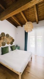a bedroom with a white bed and a wooden ceiling at La Bianca Dimora B&B in Gioia del Colle