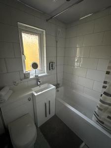 a bathroom with a toilet and a sink and a tub at My Glasgow House Robroyston in Hogganfield +11 photos