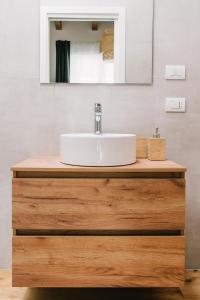 a bathroom with a white sink on a wooden vanity at La Bianca Dimora B&B in Gioia del Colle +24 photos