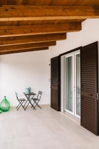 a room with wooden ceilings and a table and chairs at La Bianca Dimora B&B in Gioia del Colle
