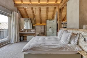 ムジェーヴにあるChalet de luxe proche du village de Megèveの大きなベッドとキッチンのある寝室