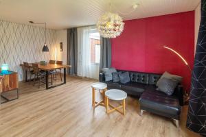 ein Wohnzimmer mit einem Sofa und einer roten Wand in der Unterkunft Ferienhaus Kim in Dornumersiel