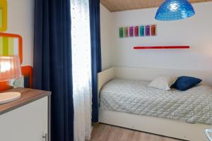 ein Schlafzimmer mit einem Bett mit einem blauen Vorhang in der Unterkunft Ferienhaus Kim in Dornumersiel