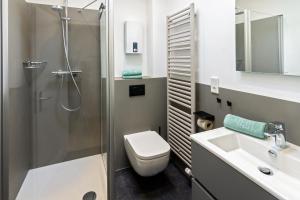 ein Badezimmer mit Dusche, Toilette und Waschbecken in der Unterkunft Ferienhaus Kim in Dornumersiel