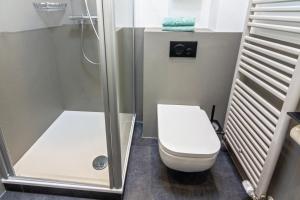 ein kleines Badezimmer mit Toilette und Dusche in der Unterkunft Ferienhaus Kim in Dornumersiel + 15 Fotos