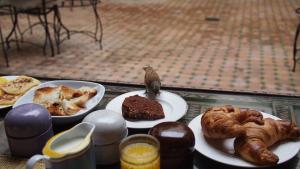un tavolo con piatti di pasticcini e un uccello in cima di Riad Cannelle a Marrakech