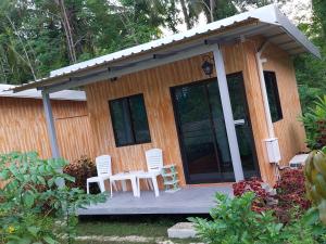 a small wooden cabin with chairs and a table at AioonHomestay Single Room in Ban Bang Bao