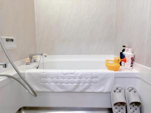 a bathroom with a bath tub with a towel and shoes at NewDayHouse日式洋房独栋最多住10人 新今宫站近温泉通天阁天王寺 机场直达 半小时到世博会 in Osaka