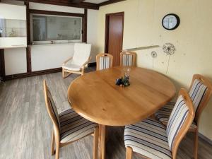 een eetkamer met een houten tafel en stoelen bij FeWo Renken in Trassenheide +14 foto's