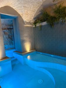 a swimming pool with blue lighting in a building at La Maison - Private wellness -Suite in Ostuni