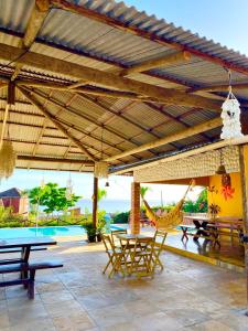 a patio with tables and chairs and a pool at Pousada La Ilha in Cajueiro