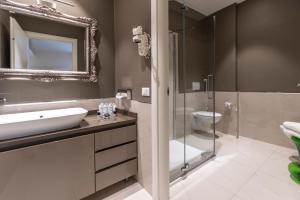 a bathroom with a sink and a glass shower at Opera Relais De Charme - Aparthotel in Verona +270 photos