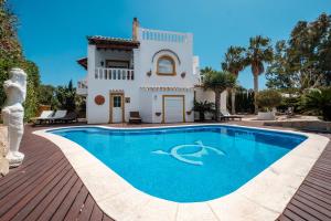 a villa with a swimming pool in front of a house at Villa Alba in Santa Eularia des Riu