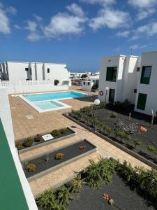 an aerial view of a swimming pool in front of a building at Sunset&Suite Puerto del Carmen in Tías