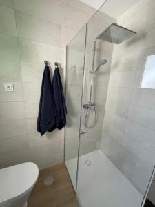 a bathroom with a glass shower with a toilet at Sunset&Suite Puerto del Carmen in Tías