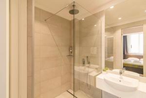 ein Badezimmer mit Glasdusche und Waschbecken in der Unterkunft Belgrade Inn Garni Hotel in Belgrad + 54 Fotos