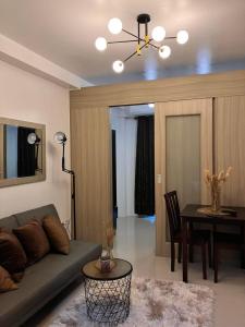a living room with a couch and a table at Shell Residences MOA by Kirstie in Manila +6 photos