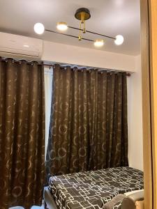 a bedroom with black curtains and a bed at Shell Residences MOA by Kirstie in Manila