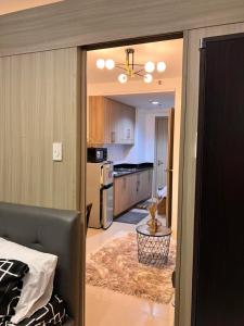 a kitchen with a couch and a living room at Shell Residences MOA by Kirstie in Manila