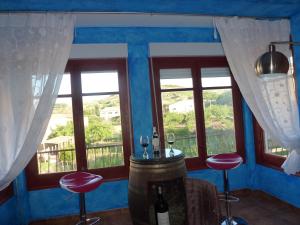 a room with two windows and a table with wine glasses at Hostal A La Sombra Del Laurel in Navarrete
