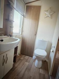 a bathroom with a white toilet and a sink at Modern caravan Robin Hood Rhyl in Rhyl