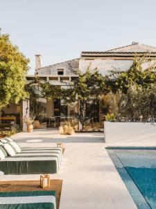 a backyard with a pool and a house at Morvedra Nou Luxury Boutique Hotel - Adults Only in Ciutadella