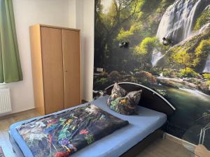 a bedroom with a large painting of a waterfall at Monteurunterkunft in Brombachtal