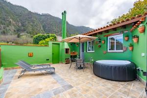 a green house with a hot tub and chairs at Casa Rural La Resbala - Casa Cardon in La Orotava