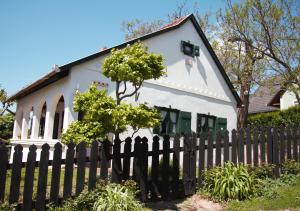 a white house with a black fence at Kemencés Vendégház in Kővágószőlős