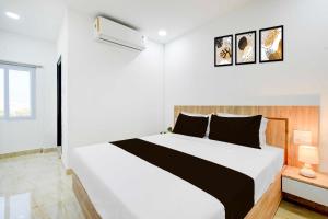 a white bedroom with a large bed and a window at Townhouse Oak LB Nagar Metro Station in Hyderabad