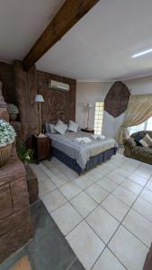 a large bedroom with a bed and a couch at La Mathil in Swartspruit +60 photos