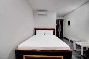 Un dormitorio con una cama y una silla dentro. en Hotel O HR, en Kundakal
