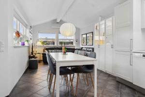 Una cocina y un comedor con una mesa y sillas blancas. en Lovely Holiday Home Near Hasmark Beach, en Otterup