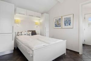 Un dormitorio blanco con una gran cama blanca. en Lovely Holiday Home Near Hasmark Beach, en Otterup