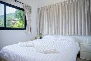 Un dormitorio con una cama blanca con una ventana. en Blue Horizon Haad Yao, Seaview 3BR Apartment 1st Floor, en Ko Pha Ngan