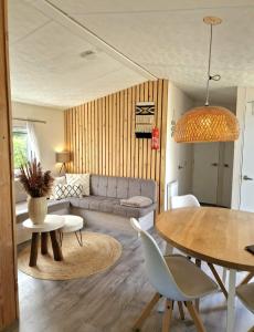 a living room with a couch and a table at EnJoy Meer und See Ferienhaus -In Lauwersoog- 1-6 Pers- 3 Schlafzimmer in Lauwersoog