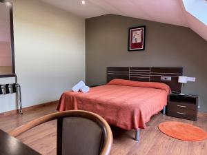 a bedroom with a bed with a red bedspread at Pensión Restaurante Tino in Germade +6 photos