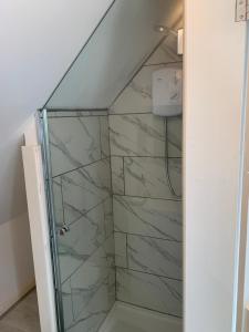 a shower with a glass door in a bathroom at Hewarts Lodge, Brand New Property, 1 Mile From The Beach, 15 Minutes From All Goodwood Events in Bognor Regis +8 photos