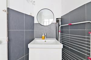 a bathroom with a white sink and a mirror at Heart of Paris-1BR-2P-Montparnasse -Free Netflix in Paris +7 photos