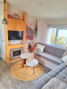a living room with a couch and a table at EnJoy Meer und See Ferienhaus -In Lauwersoog- 1-6 Pers- 3 Schlafzimmer in Lauwersoog