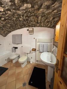 a bathroom with two toilets and a sink and a tub at La casetta dello gnomo in Saint Nicolas +29 photos
