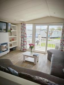 a living room with a couch and a table at Lyons robin hood lodge Rhyl in Rhyl +12 photos
