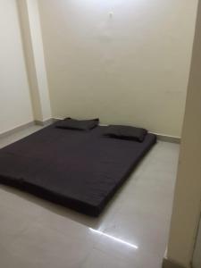 リシケーシュにあるYog Kul HomeStay - Budgetの白い床の部屋に黒いベッドがある