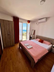 a bedroom with a large bed and a large window at Apartments Nautilus in Ulcinj