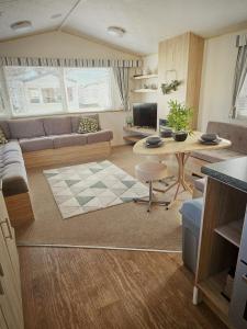 リルにあるLyon’s Robin Hood Rhyl caravan sbwのソファとテーブルのあるリビングルーム