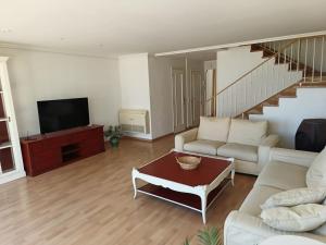 a living room with a couch and a tv at Bungalow primera línea de playa in El Campello