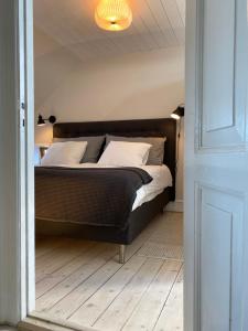 ein Schlafzimmer mit einem großen Bett und weißen Kissen in der Unterkunft Torvet 4 in Svendborg