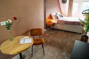 a small room with a bed and a table at Boetiekhotel Het Huis in Fluitenberg