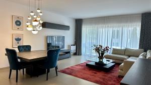 a living room with a table and a couch at Cavalo Branco Portugal in Quarteira