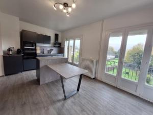 a kitchen with a table in the middle of a room at Le Nid Canin in Polminhac